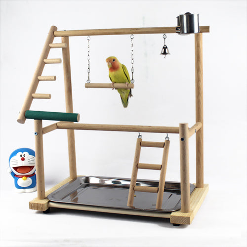 Wooden bird playstand with a parrot perched on it, featuring ladders and platforms.